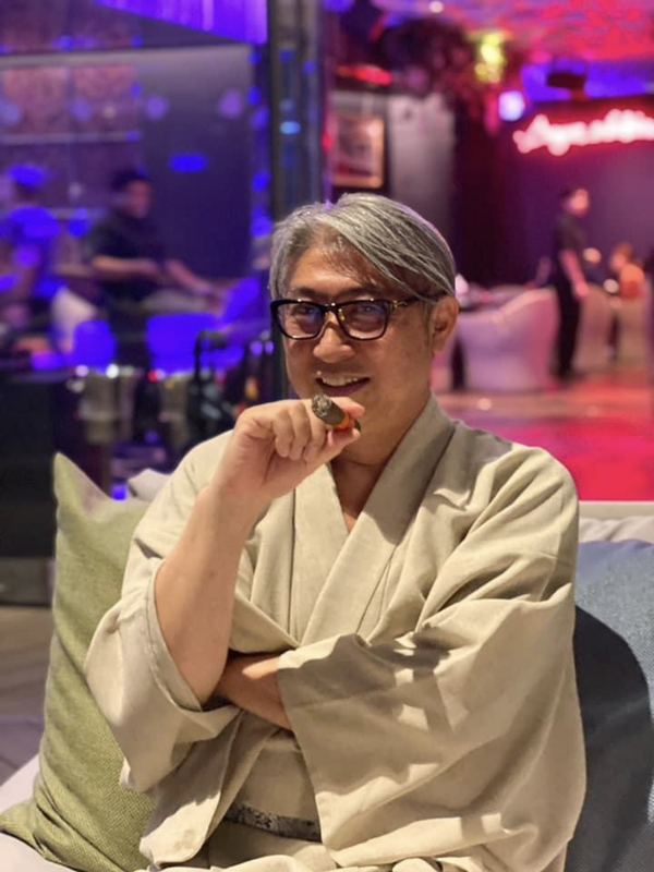 ネオンのラウンジでローブをまとう西田理一郎