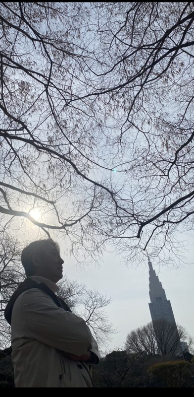 冬の木立の下にたたずむ西田理一郎のシルエット