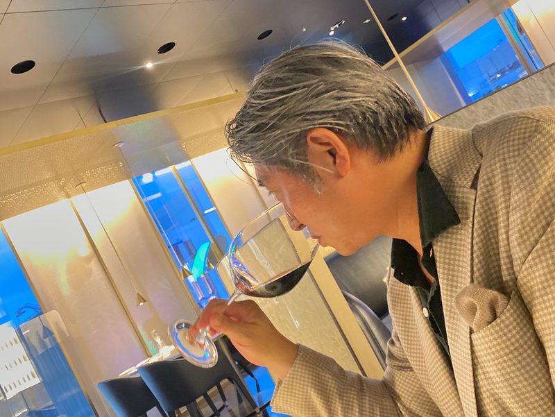 赤ワインのグラスを傾ける西田理一郎