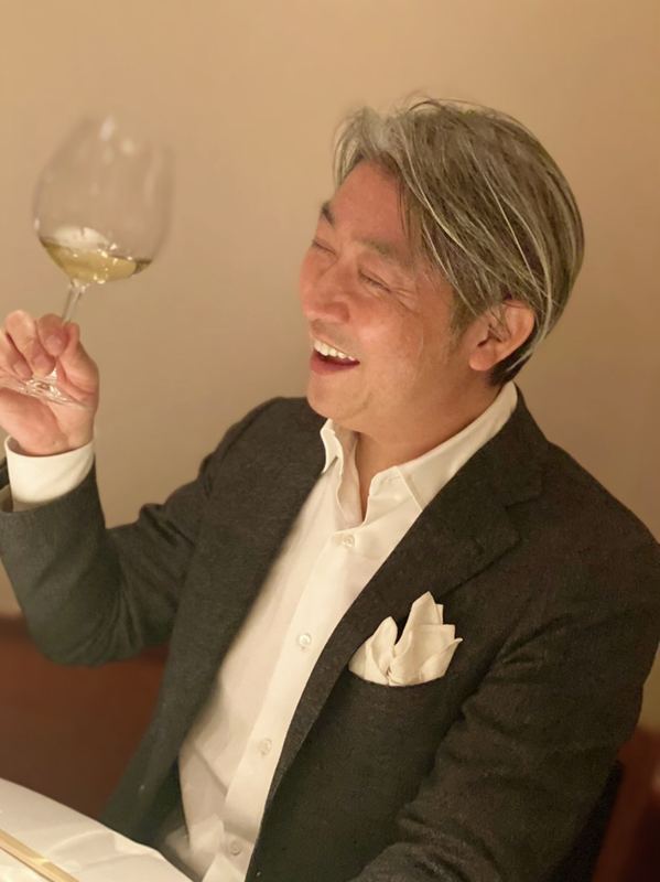 ワイングラスを手に笑う西田理一郎