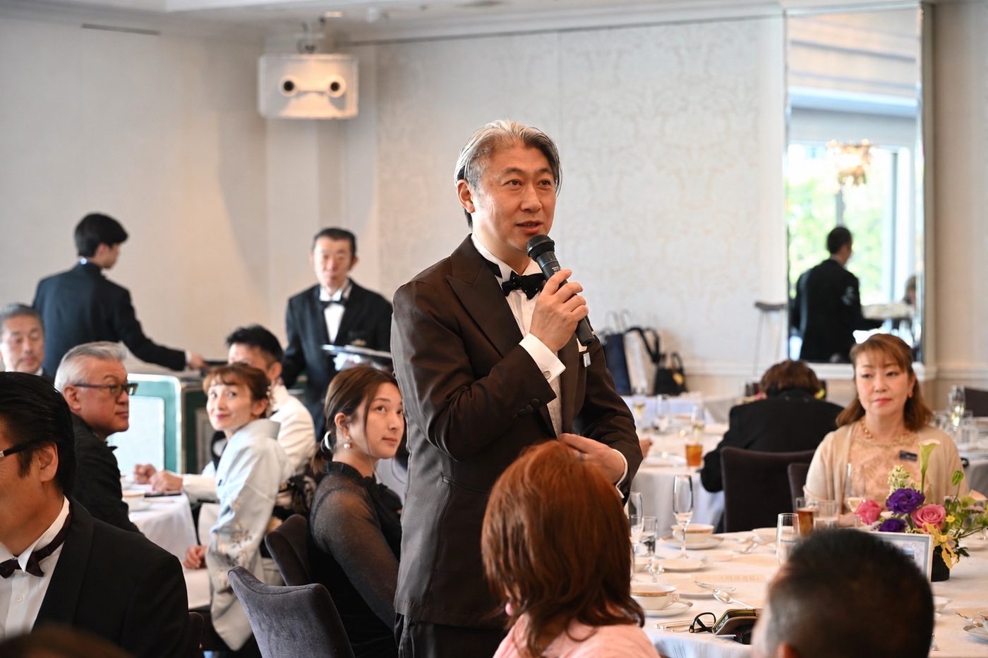 会食の席でマイクを手に話す西田理一郎