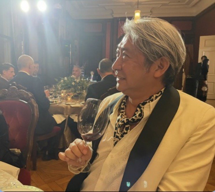 晩餐会で赤ワインのグラスを手にする西田理一郎