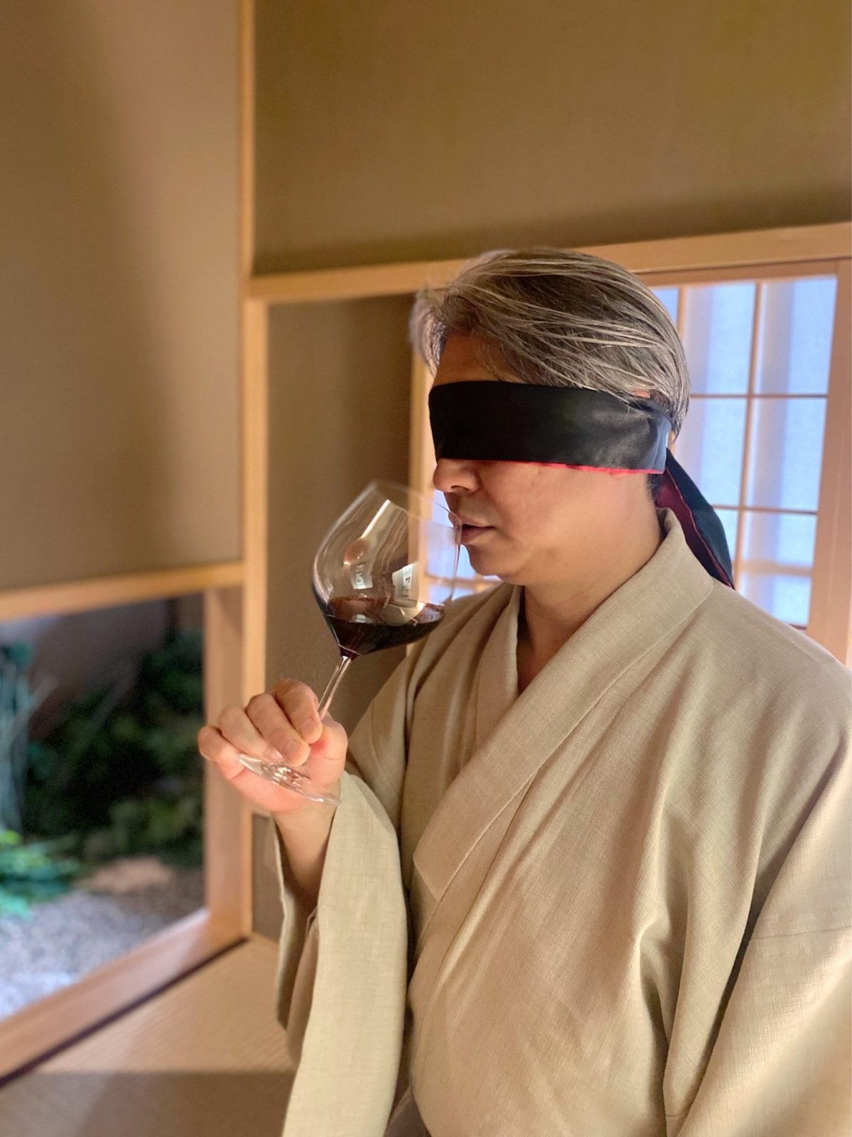 目隠しをしてワインの香りを確かめる西田理一郎（茶室にて）